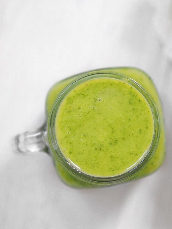 glowing green smoothie in mason jar with handle