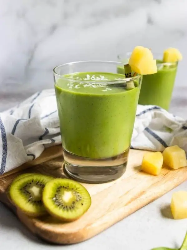 two kiwi pineapple green smoothies in short glasses