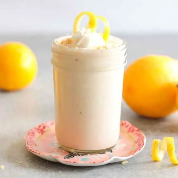 lemon cream pie protein shake in small glass with lemon zest