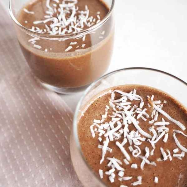 two mocha protein shakes in glass with coconut topping