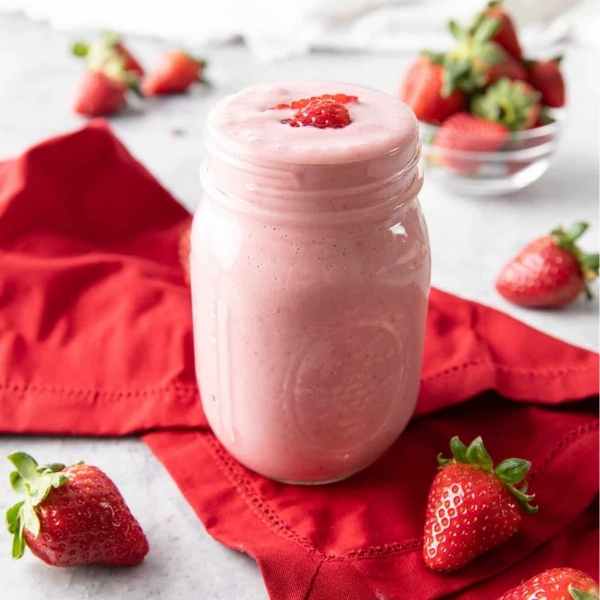 strawberry vegan protein shake in jar with fresh strawberries